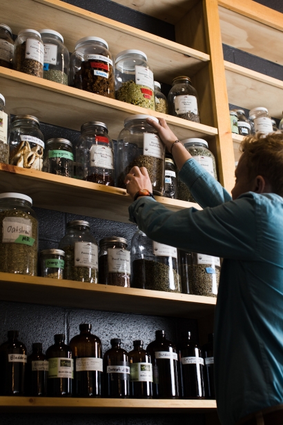 One of Railyard Apothecary's in Burlington, Vermont employees reaching for one of their many jarred herbs.