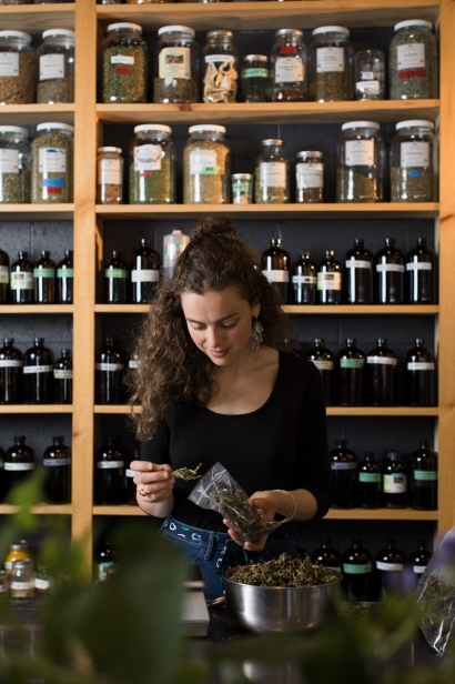 One of Railyard Apothecary's in Burlington, Vermont employees processing herbs for their stock.